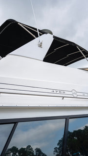 Close-up of a white Bayliner 4788 boat hull showing a glossy, mirror-like gelcoat finish after Re-Gel restoration.