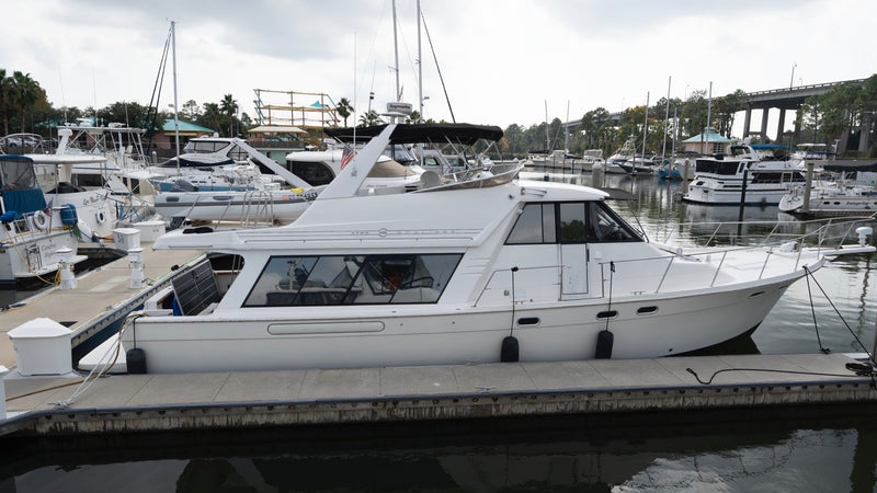 White Bayliner cabin cruiser with a glossy, restored hull docked at a marina after Re-Gel gelcoat restoration.